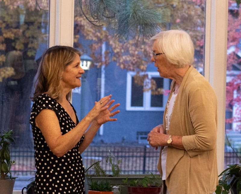 two woman having a conversation at an Accola event